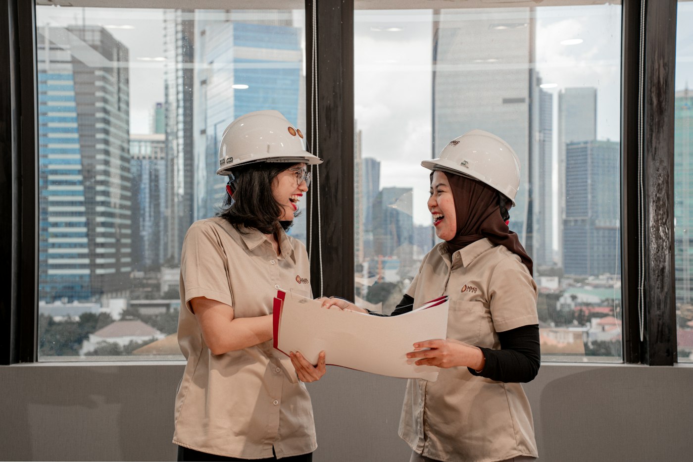 Two project managers in hard hats discussing construction plans