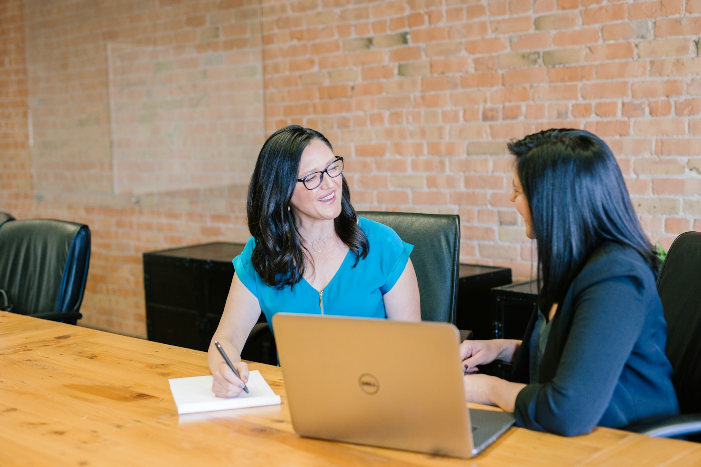 Two colleagues reviewing work together on a laptop