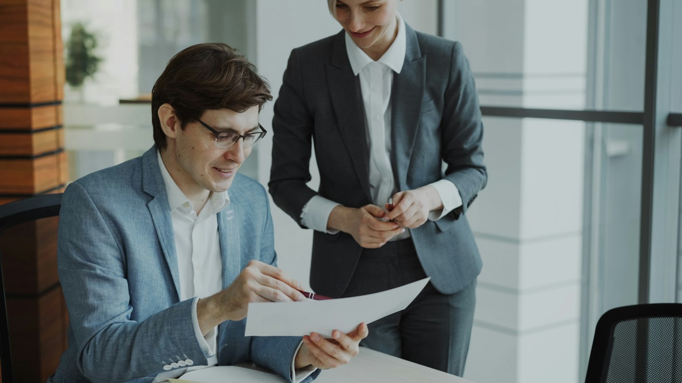 Two professionals reviewing documents together in an office