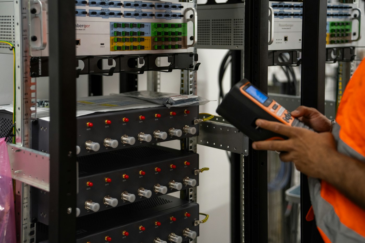 Technician inspecting server racks with a diagnostic tool