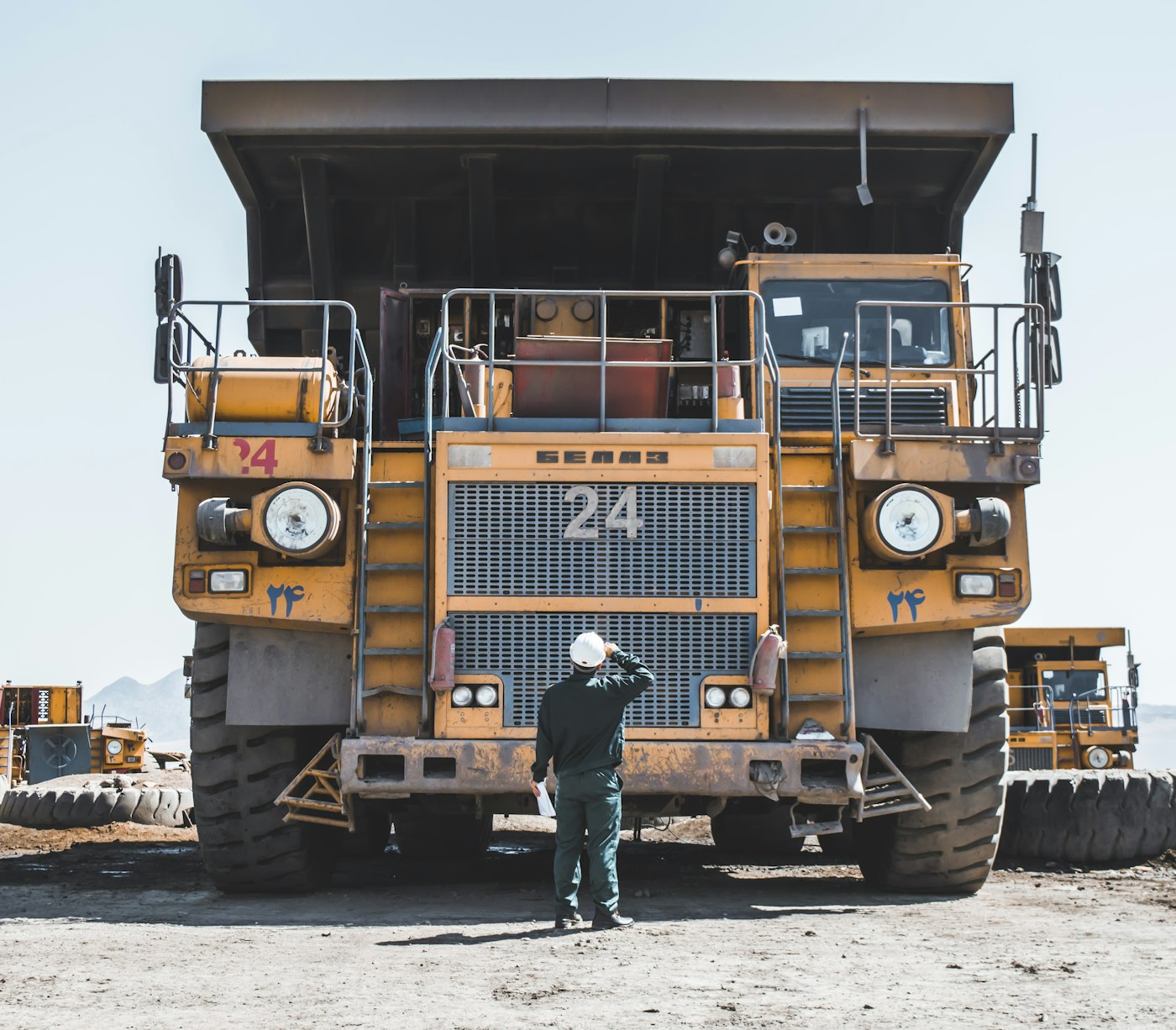 Site supervisor standing beside a large mining haul truck